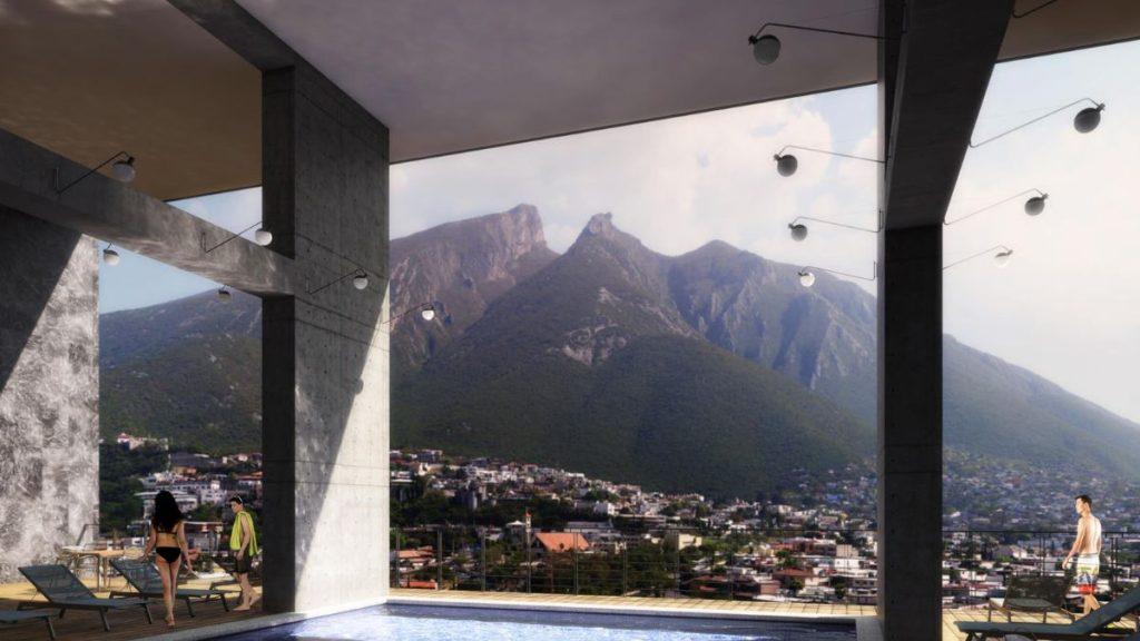 Adults in swimwear on a pool deck with a city and mountains in the background.